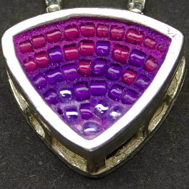 Triangular pendant with purple and raspberry bead pattern on a black background